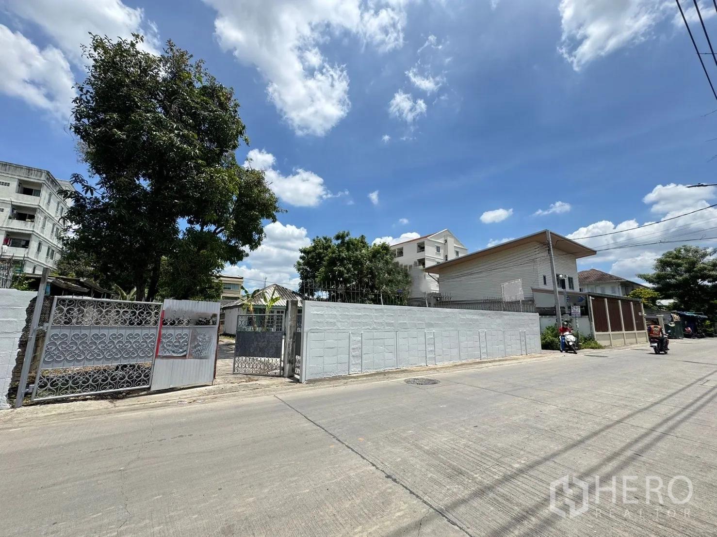 Detached House for rent in Mueang Samut Prakan, Samut Prakan - Street view of the gated entrance and boundary wall of the property in a residential area.
