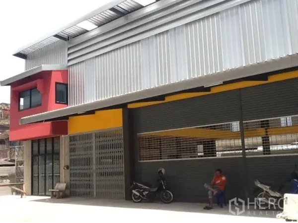 货栈 出租在Bang Kapi, Bangkok - 当代风格仓库门面，超大卷闸与带顶前场可停车。