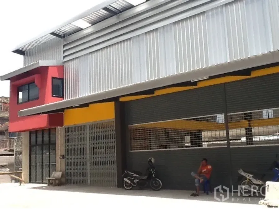 货栈 出租在Bang Kapi, Bangkok - 当代风格仓库门面，超大卷闸与带顶前场可停车。