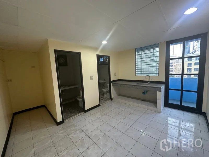 办公空间 出租在Bang Rak, Bangkok - 茶水间区域，配长水槽、两间洗手间，并有小阳台门。