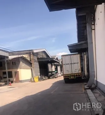 Warehouse for rent in Chachoengsao - Alley behind warehouses with trailer truck access and designated loading zones.