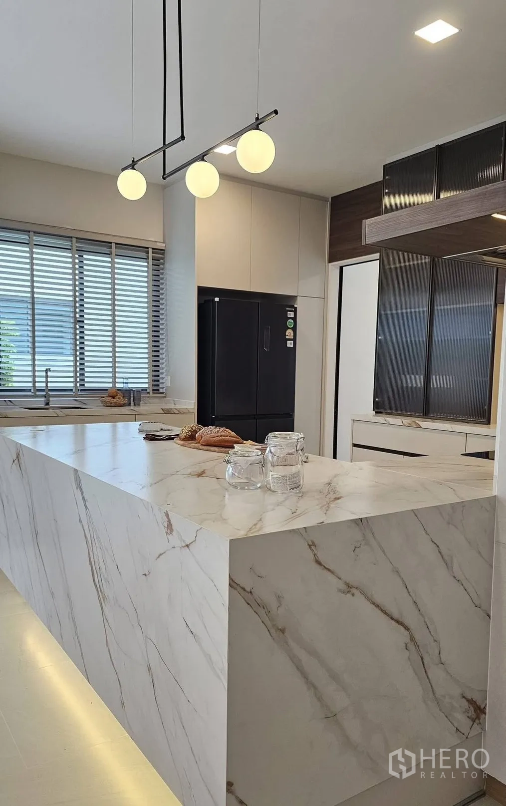 บ้านเดี่ยว for rent in Bang Phli, Samut Prakan - ครัวสวยด้วยไอส์แลนด์หินอ่อนแบบน้ำตก โคมแขวน และตู้เย็นสีดำ.