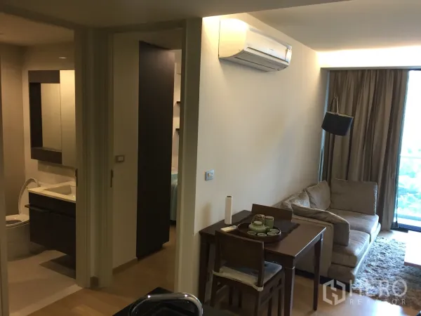 คอนโด ให้เช่าหรือขายในWatthana, Bangkok - พื้นที่นั่งเล่นและรับประทานอาหารอบอุ่น มีโซฟา โต๊ะอาหาร เครื่องปรับอากาศ และทางเข้าห้องนอนกับห้องน้ำ.