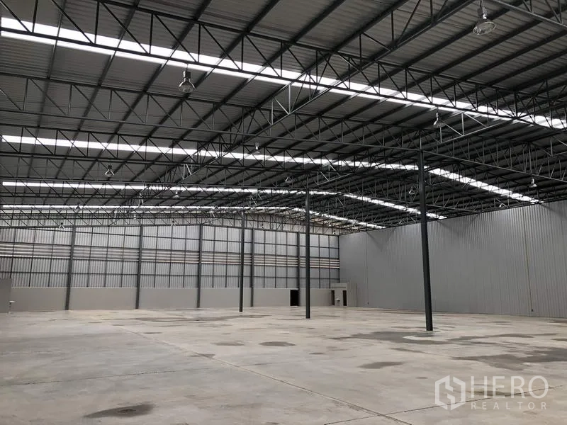 货栈 出租在Lat Krabang, Bangkok - 宽敞仓库内部，高钢桁架屋顶、天窗带来自然采光，混凝土地面
