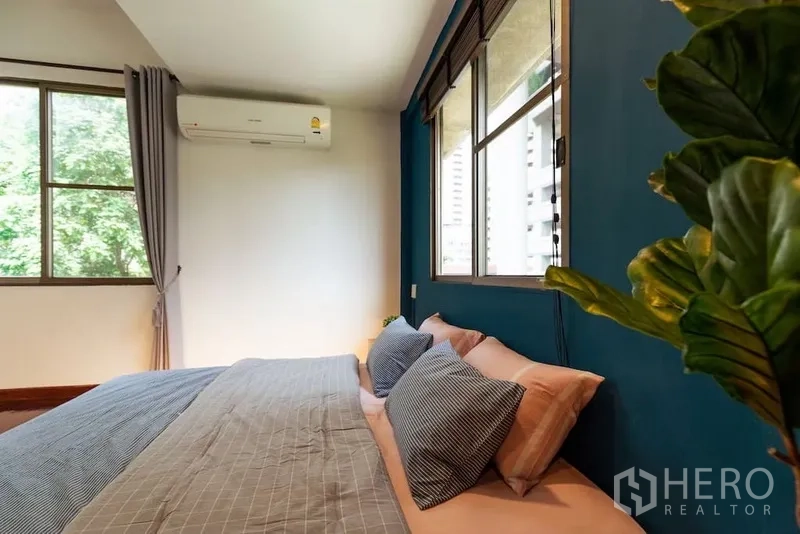 ทาวน์เฮาส์ ให้เช่าในWatthana, Bangkok - ห้องนอนรับแสง ผนังสีน้ำเงิน หน้าต่างคู่ และเครื่องปรับอากาศ