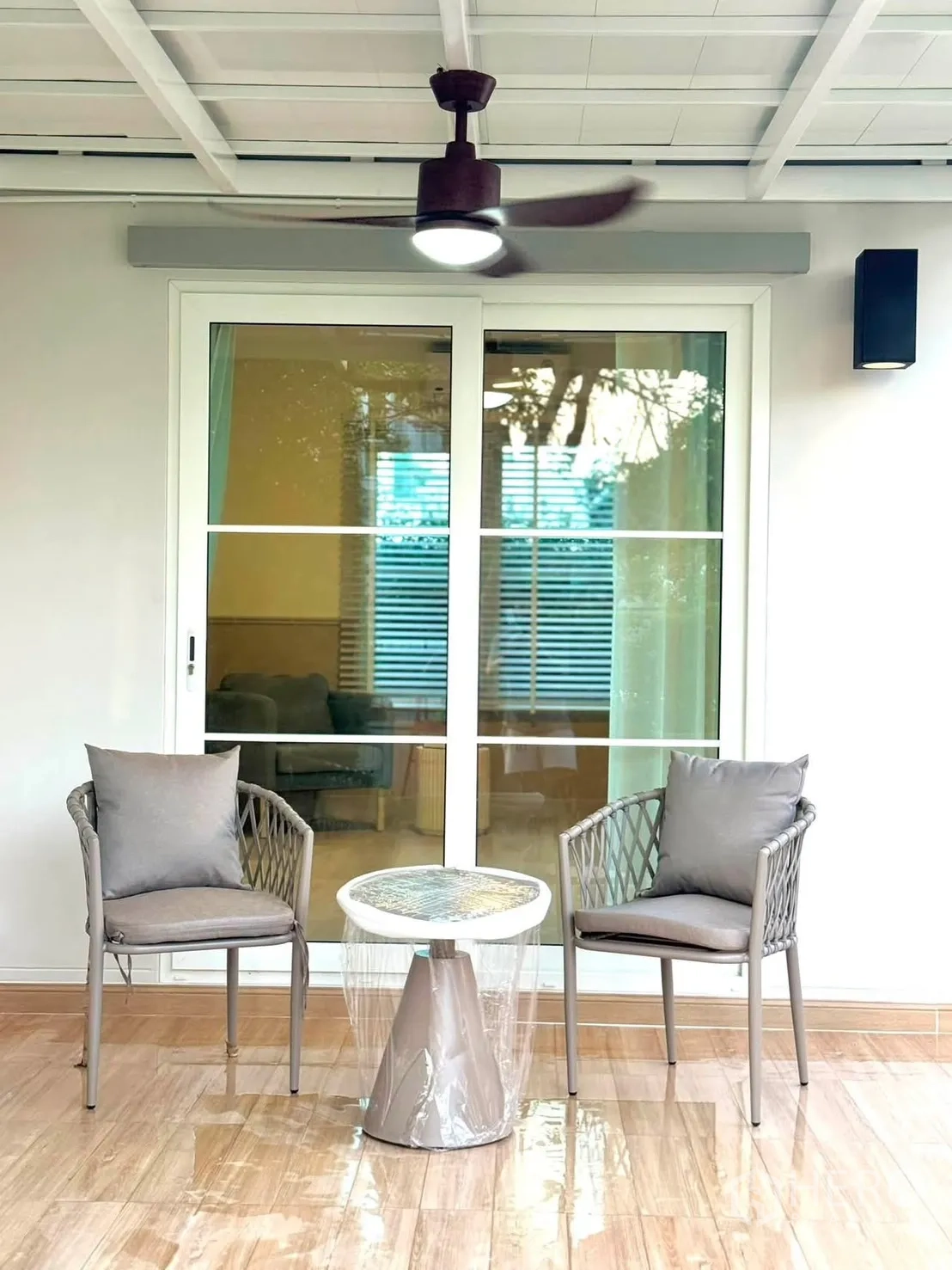 独栋房屋 for rent in Bang Phli, Samut Prakan - 露台上两把椅子与小圆桌，天花吊扇，旁为推拉玻璃门。