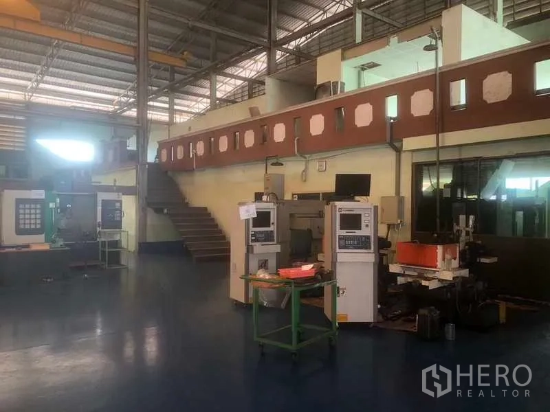 Warehouse for sale in Rayong - Workshop area with mezzanine office and CNC machines.