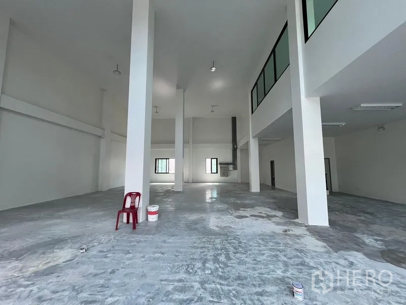 货栈 出租在Bang Sao Thong, Samut Prakan - 仓库内净跨空间，结构立柱显著，夹层俯瞰作业区