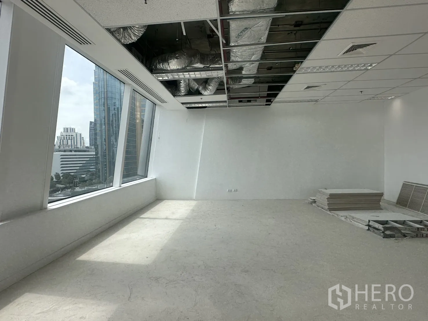 ออฟฟิศ for rent in Watthana, Bangkok - โซนรับแสงพร้อมงานระบบบนฝ้าเปิด และแผ่นวัสดุกองอยู่บนพื้น