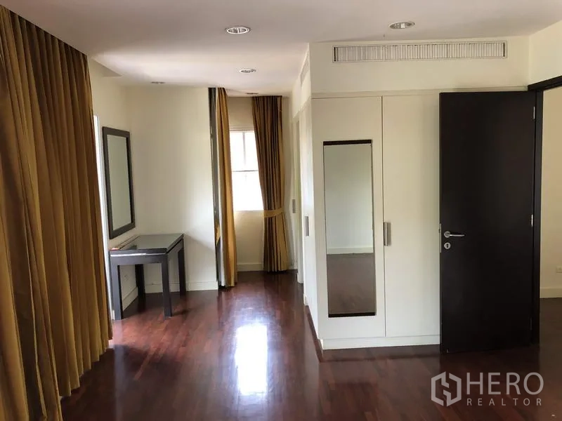 บ้าน ขายในWang Thonglang, Bangkok - ห้องนอนชั้นบนปูพื้นไม้ มีตู้บิลท์อินและมุมแต่งตัวพร้อมโต๊ะ.