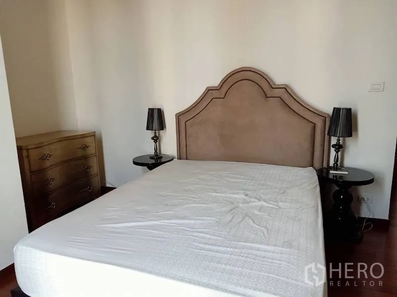 คอนโด ให้เช่าในKhlong Toei, Bangkok - ห้องนอนใหญ่หัวเตียงบุผ้า โคมไฟหัวเตียงคู่ และตู้ลิ้นชัก