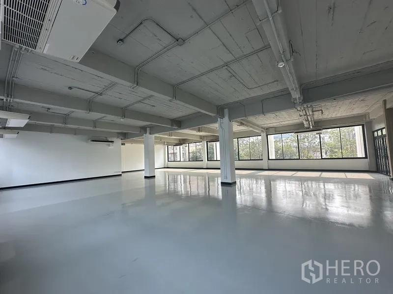 Office Space for rent - Spacious open-plan office with polished epoxy floor, exposed ceiling and large windows.