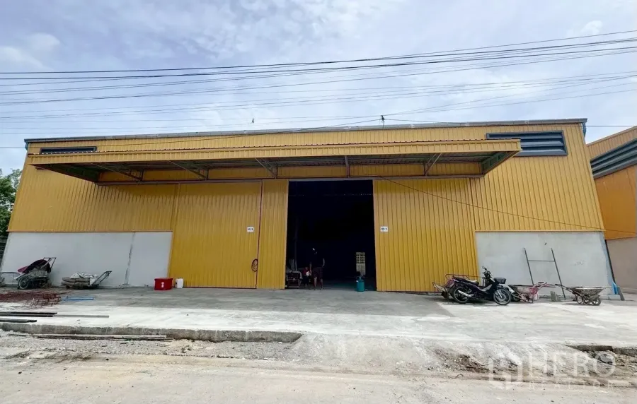 货栈 出租在Khlong Luang, Pathum Thani - 黄色金属外墙仓库正立面，超宽滑动门与装卸前坪。