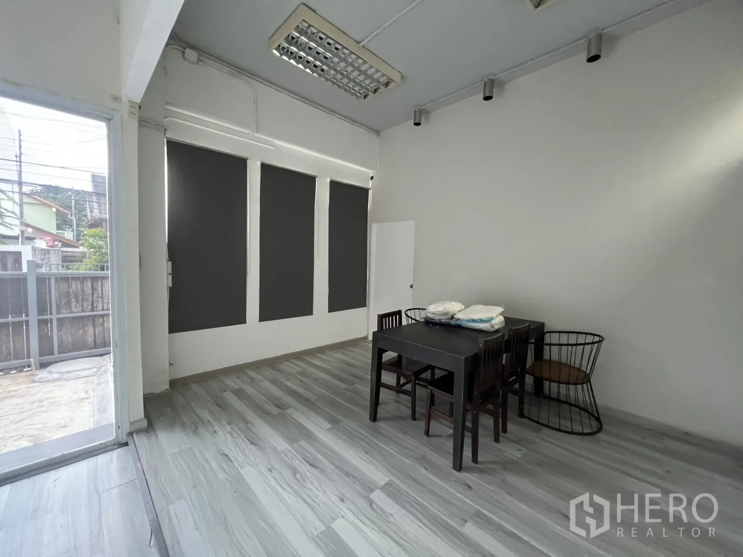 สำนักงานที่บ้าน ให้เช่าในPhra Khanong, Bangkok - พื้นที่รับประทานอาหาร/ประชุมชั้นล่าง โต๊ะชุด ม่านทึบ และประตูกระจกสู่ลาน