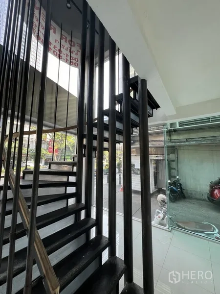 พื้นที่ขายปลีก ให้เช่าในBang Rak, Bangkok - บันไดเหล็กโครงราวสีดำ ขนาบผนังกระจกเต็มความสูง