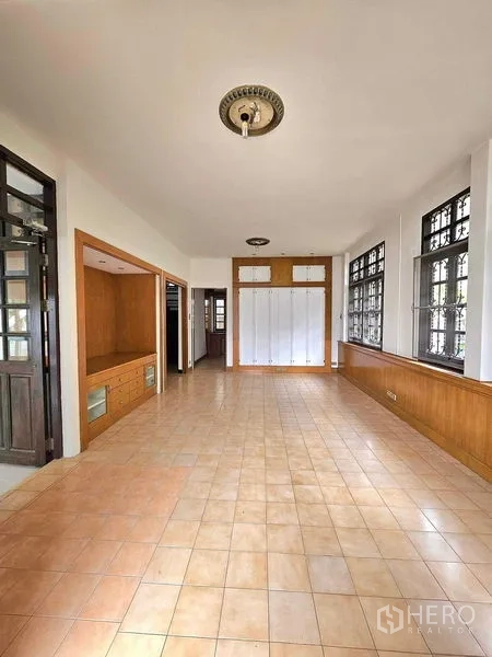 Detached House for sale in Saphan Sung, Bangkok - Spacious multipurpose room with warm-tone tiles, built-in cabinetry and large windows.