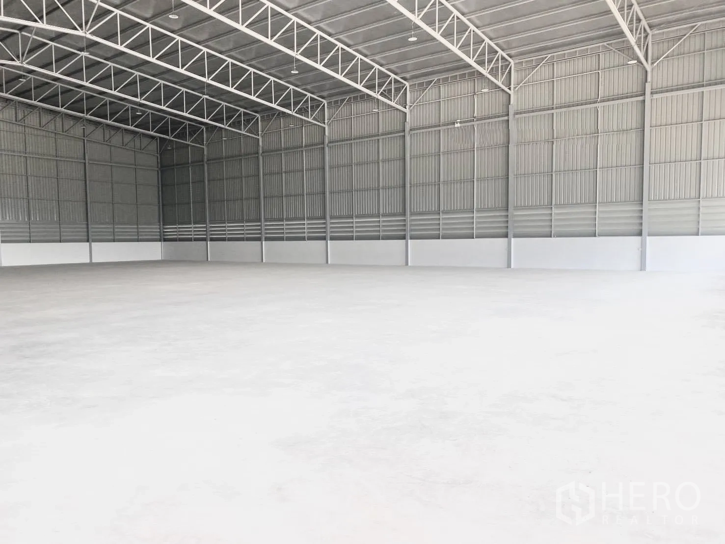 Warehouse for rent in Bang Bo, Samut Prakan - Spacious warehouse interior with high steel trusses and smooth concrete floor.