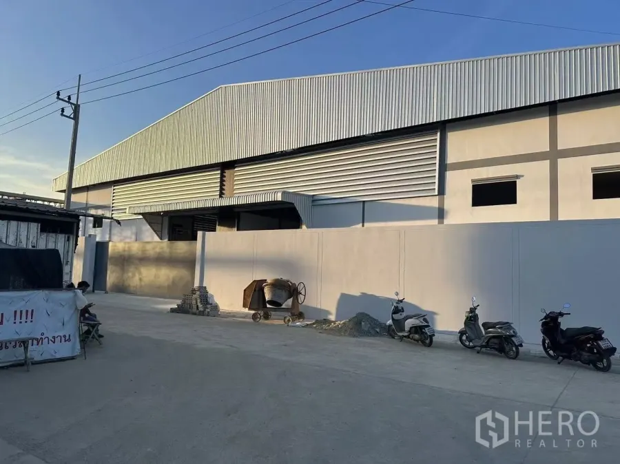 工厂 出租在Nong Khaem, Bangkok - 现代化工厂外观，高金属屋顶、实体围墙与宽阔混凝土车道。