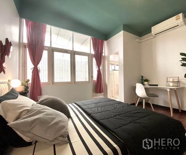 ทาวน์เฮาส์ ให้เช่าในKhlong Toei, Bangkok - มุมห้องนอนเห็นโต๊ะทำงาน เครื่องปรับอากาศ และทางเข้าห้องน้ำในตัว