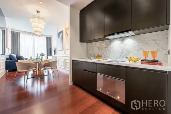 คอนโด ให้เช่าในWatthana, Bangkok - ครัวบิลต์อินโทนเข้ม ผนังหินอ่อน พื้นไม้ ต่อเนื่องสู่พื้นที่ทานอาหารพร้อมโคมระย้า
