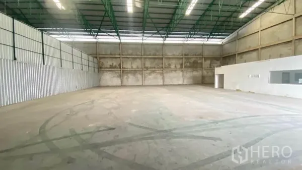 货栈 出租在Samut Prakan - 仓库内部空间，高钢结构屋顶与混凝土墙面。