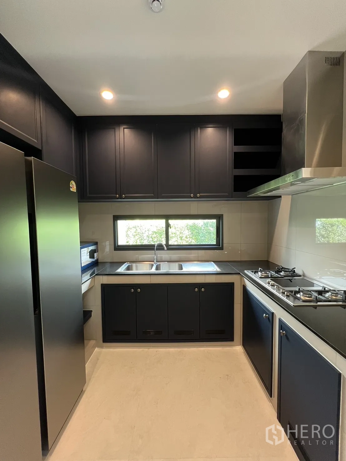 บ้านเดี่ยว for rent in Bang Phli, Samut Prakan - ครัวปิดโทนเข้มพร้อมเตาแก๊ส เครื่องดูดควัน อ่างล้างจานคู่ และหน้าต่าง