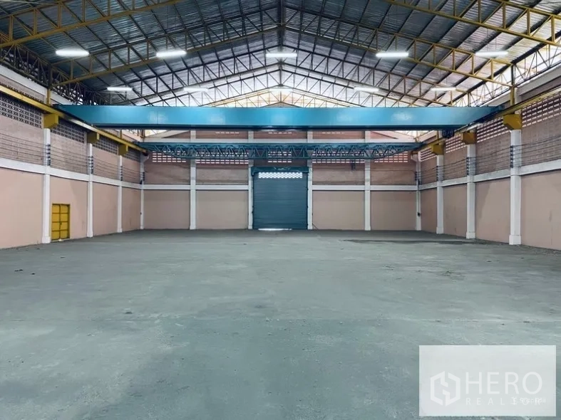 Warehouse for rent in Sam Phran, Nakhon Pathom - Wide interior bay featuring an overhead steel beam suitable for a hoist and a central roller shutter.