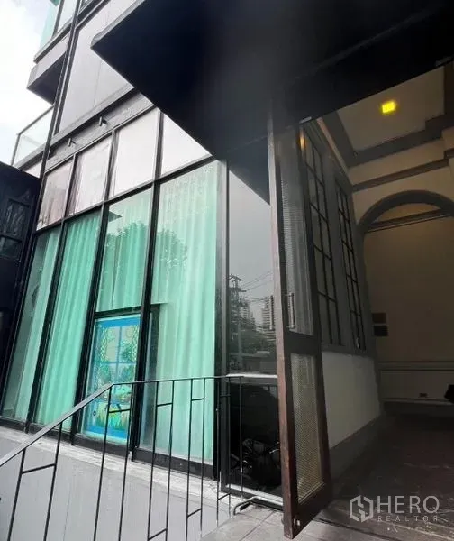 พื้นที่ขายปลีก ให้เช่าในWatthana, Bangkok - บันไดนอกอาคารสู่หน้าร้านกระจกสูงเต็มผนังพร้อมกันสาด