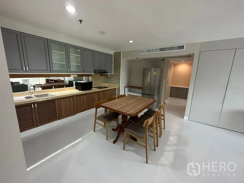 คอนโด ให้เช่าในWatthana, Bangkok - ครัวเปิด ตู้แขวนสีเทา ตู้ล่างลายไม้ ชุดโต๊ะทานข้าว และตู้เย็นขนาดใหญ่