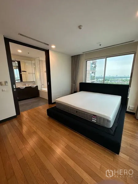 Condominium for rent in Yan Nawa, Bangkok - Primary bedroom with city view window and ensuite bathroom.
