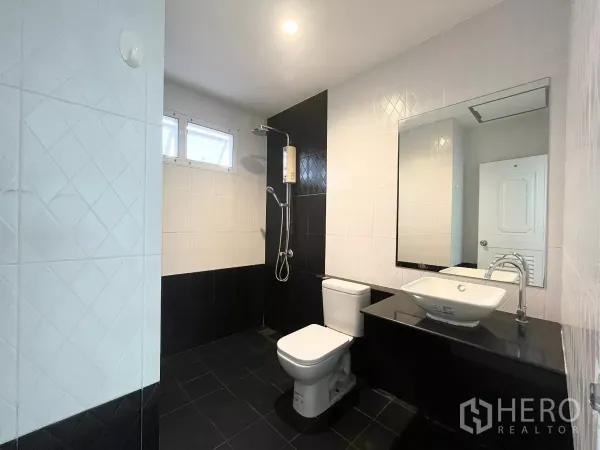 Home Office for rent in Bueng Kum, Bangkok - Modern black-and-white tiled bathroom with shower, toilet and vanity.