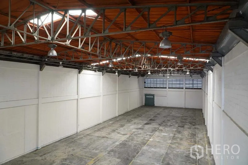 Factory for rent in Bang Sao Thong, Samut Prakan - Elevated view of expansive warehouse bay with truss roof and skylights.