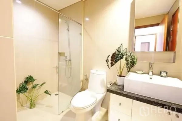 คอนโด ให้เช่าในKhlong San, Bangkok - ห้องน้ำสว่างพร้อมตู้กระจกอาบน้ำ อ่างล้างหน้าสีขาว และสุขภัณฑ์สมัยใหม่ตกแต่งด้วยต้นไม้