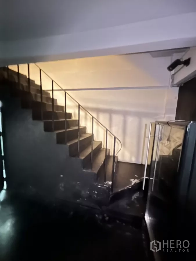 店屋 出租在Watthana, Bangkok - 入口处黑色楼梯与墙面，通往上层。