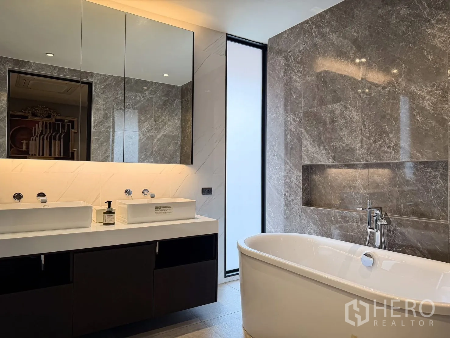 Detached House for rent or sale in Lak Si, Bangkok - Luxurious bathroom with freestanding tub, double vanity, and grey stone tiles.