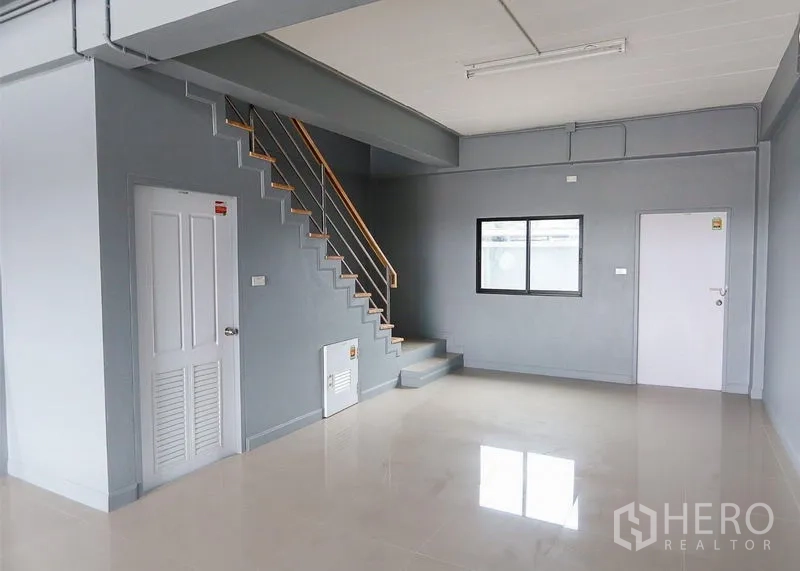 Shophouse for sale in Lam Luk Ka, Pathum Thani - Ground-floor retail space featuring a staircase, windows and internal doors.