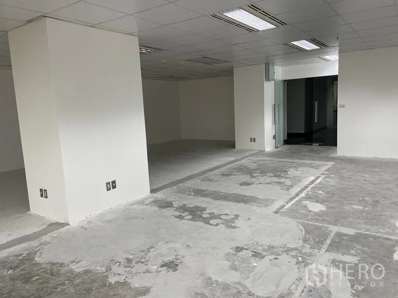 办公空间 出租在Din Daeng, Bangkok - 未装修办公楼层，白色立柱与玻璃入口门。