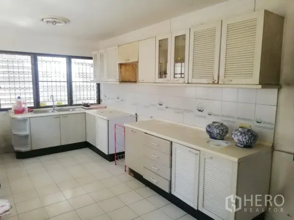 零售空间 出租在Khlong Toei, Bangkok - 宽敞厨房，L形操作台、白色橱柜与瓷砖墙面