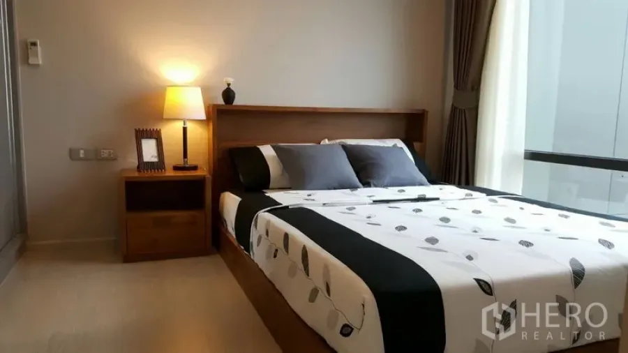 คอนโด ให้เช่าในKhlong Toei, Bangkok - ห้องนอนอบอุ่น เตียงคู่ โคมไฟหัวเตียง และหน้าต่างบานใหญ่พร้อมผ้าม่าน