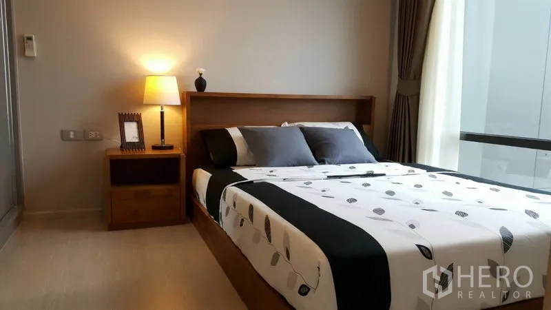 คอนโด ให้เช่าในKhlong Toei, Bangkok - ห้องนอนอบอุ่น เตียงคู่ โคมไฟหัวเตียง และหน้าต่างบานใหญ่พร้อมผ้าม่าน