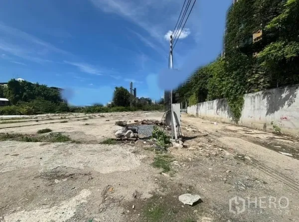 ที่ดิน ให้เช่าในKhlong Toei, Bangkok - แปลงที่ดินโล่ง พื้นคอนกรีต เสาไฟ และกำแพงรั้ว ใต้ท้องฟ้าสีฟ้า ย่านเอกมัย