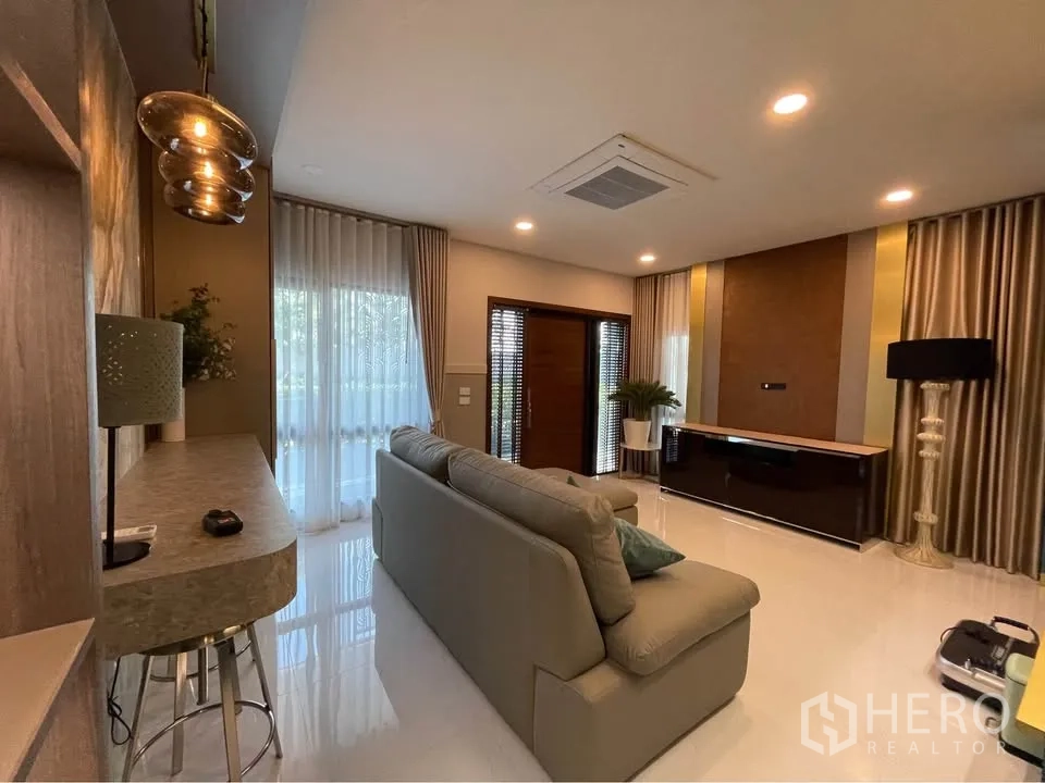 บ้านเดี่ยว for rent or sale in Bang Phli, Samut Prakan - ห้องนั่งเล่นสว่างด้วยโซฟาขนาดใหญ่ ตู้วางทีวี และไฟดาวน์ไลท์