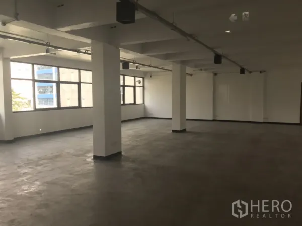 สำนักงาน ให้เช่าในKhlong Toei, Bangkok - พื้นที่สำนักงานโล่งกว้าง มีเสา โคมไฟราง และหน้าต่างยาวตลอดแนวผนัง
