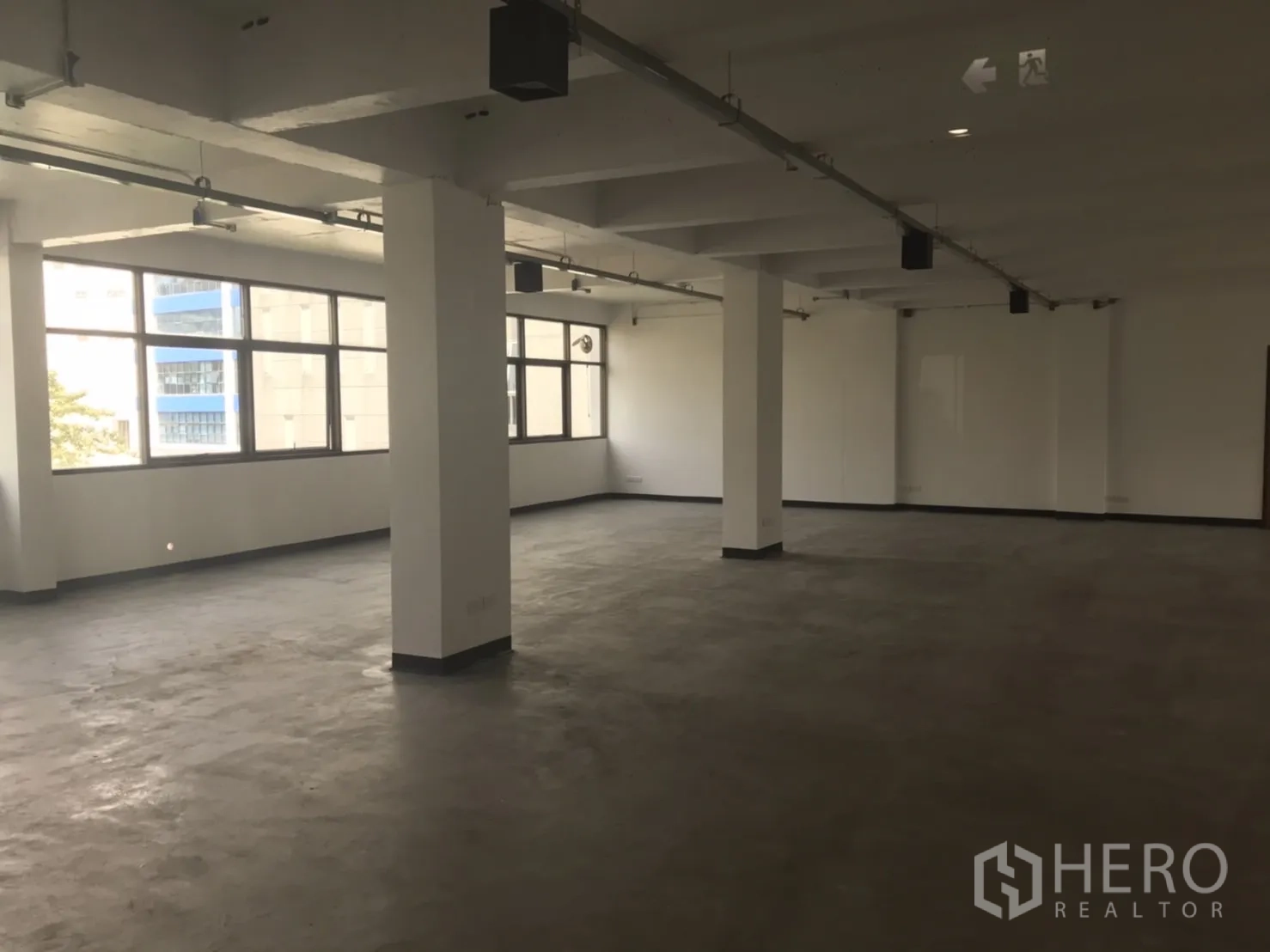 สำนักงาน ให้เช่าในKhlong Toei, Bangkok - พื้นที่สำนักงานโล่งกว้าง มีเสา โคมไฟราง และหน้าต่างยาวตลอดแนวผนัง