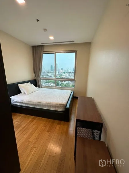 Condominium for rent in Yan Nawa, Bangkok - Second bedroom with wide window, bed and desk, overlooking the city.