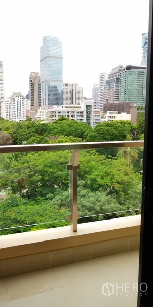 Condominium for rent in Sathon, Bangkok - Private balcony overlooking green treetops and the Bangkok skyline.
