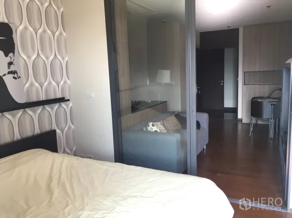 คอนโด ให้เช่าในKhlong Toei, Bangkok - มุมมองจากห้องนอนผ่านผนังกระจกสไลด์ไปยังห้องนั่งเล่นพร้อมตู้บิวท์อิน