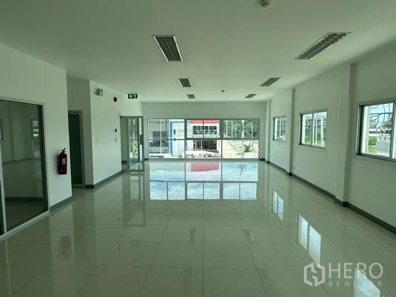 โรงงาน ให้เช่าในMueang Samut Prakan, Samut Prakan - พื้นที่สำนักงานขนาดใหญ่ กระจกเต็มบานมองเห็นด้านหน้าอาคาร พร้อมป้ายทางออกฉุกเฉิน