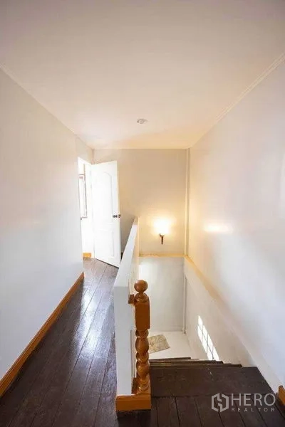 Home Office for rent in Watthana, Bangkok - Staircase landing with wooden handrail leading to the upper floor of the home office.