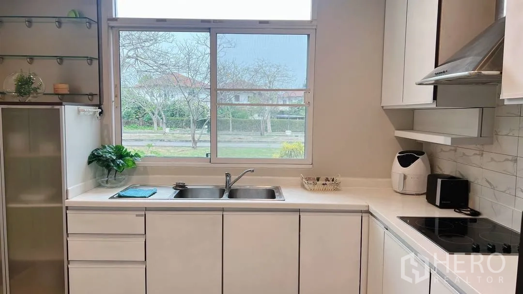 Detached House for rent in Lat Krabang, Bangkok - Bright white kitchen with double sink and large window.